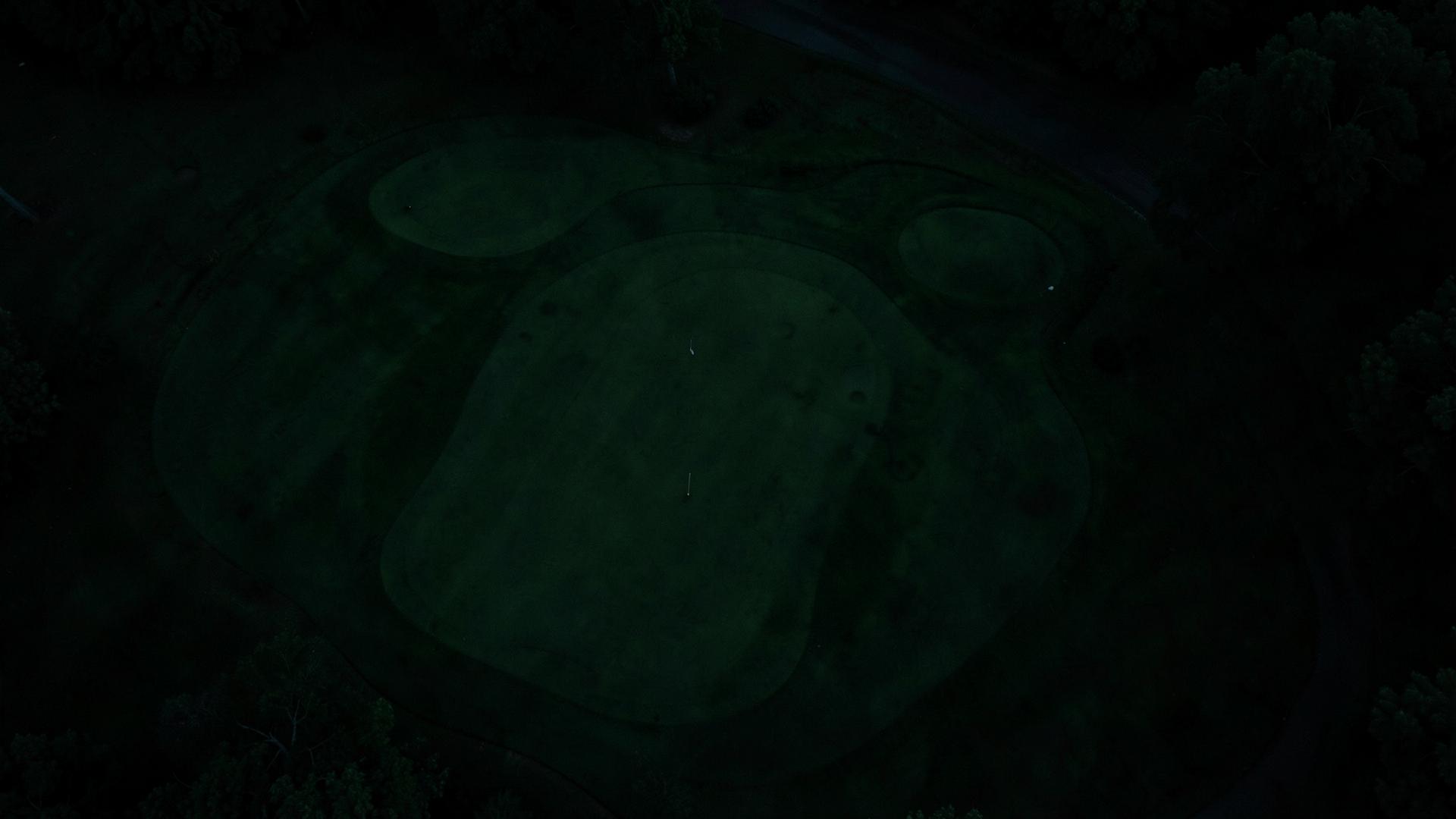 Golfer walking a coastal fairway at dusk